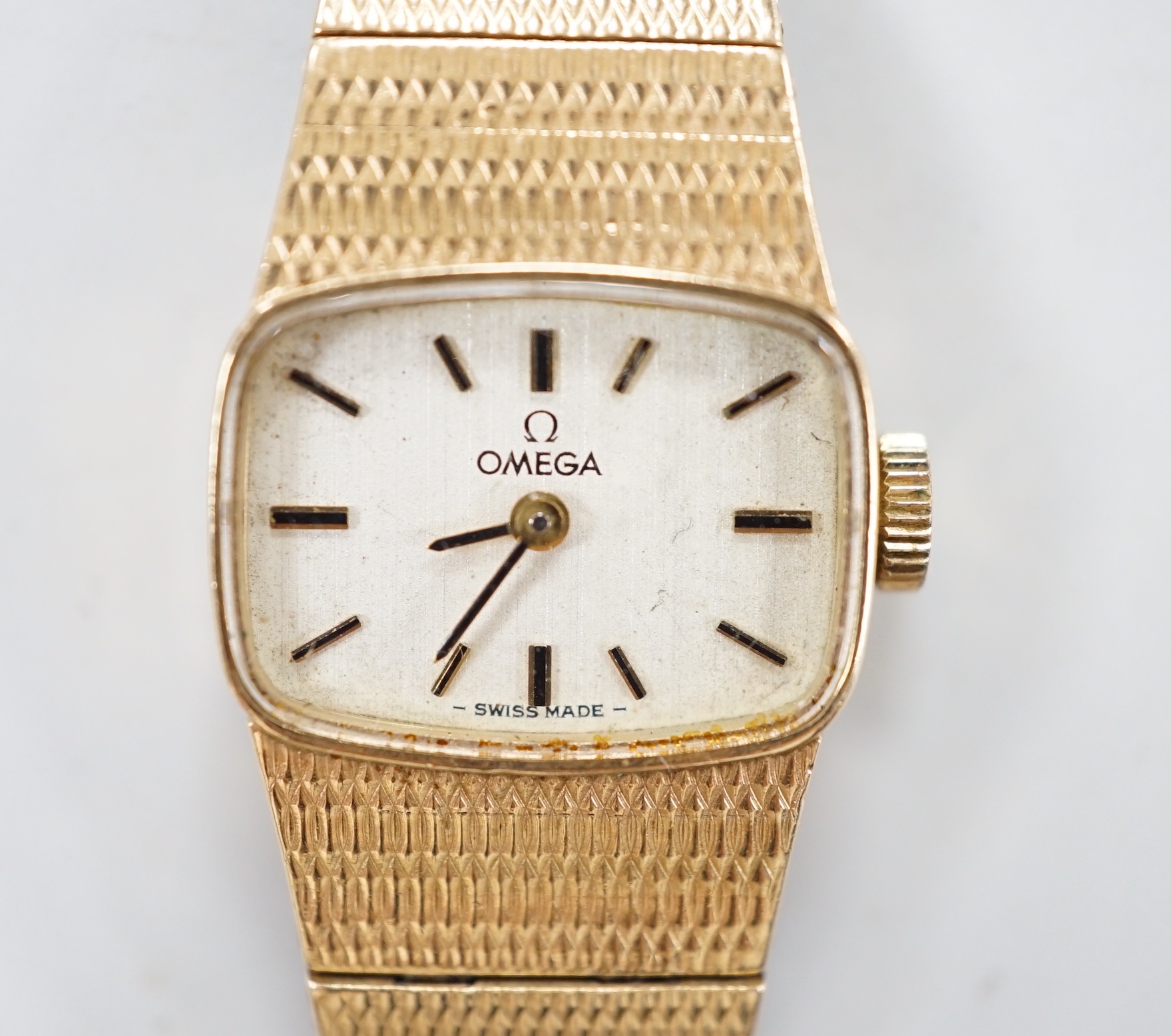 A lady's Omega 9ct gold manual wind wrist watch, with integral 9ct gold bracelet, gross weight 31.3 grams.